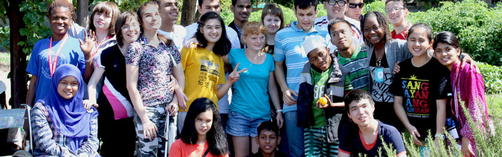 Group of students with disabilities pose in outdoor setting.