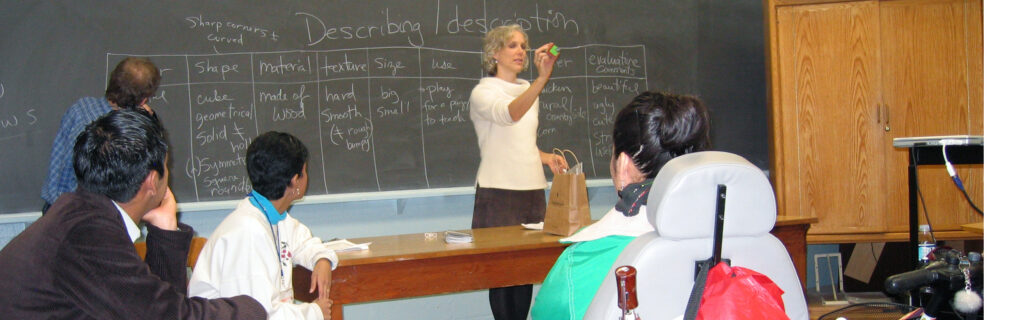 woman teaching ESL in front of class including student in wheelchair.