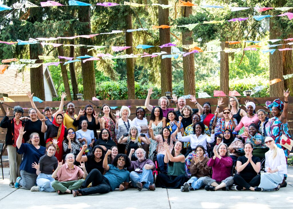 Large group of the WILD delegation with interpreters, MIUSA staff and GDDI participants waving and smiling.
