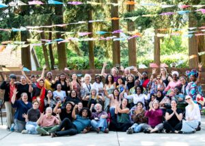 Large group of the WILD delegation with interpreters, MIUSA staff and GDDI participants waving and smiling.