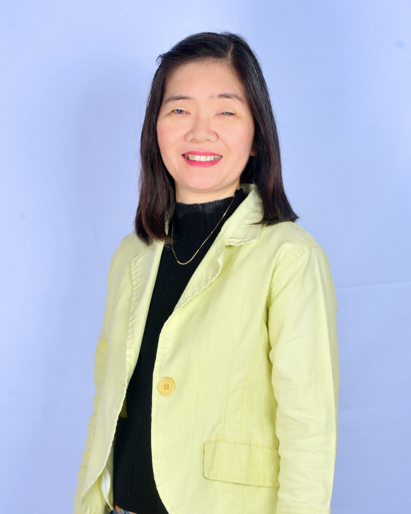 Professional portrait of Gina Rose wearing yellow blazer, smiling towards the camera