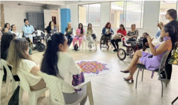 A circle of participants listen to trainer Andrea during a WILD-Colombia workshop.